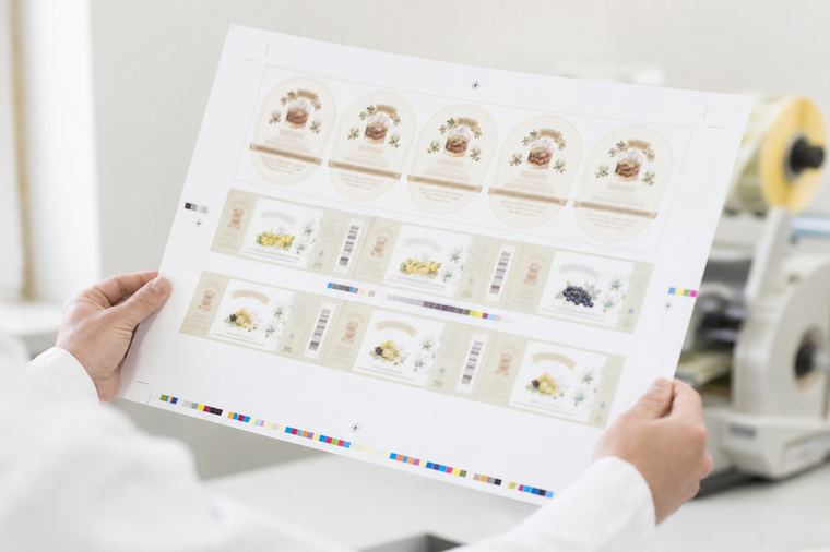 Fogli di stampa impilati su un piano chiaro, come le bozze di etichetta da controllare.